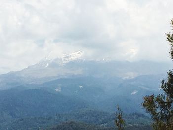 Scenic view of mountains against cloudy sky