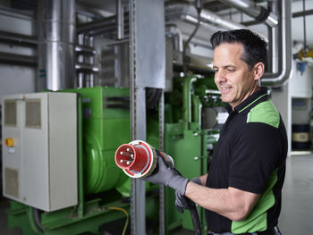 Combined heat and power plant, worker holding high current plug