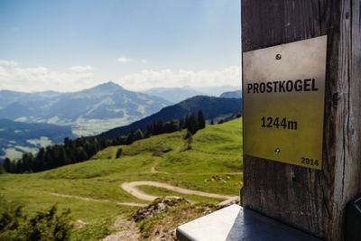 Road sign on landscape against sky