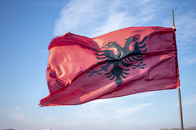 Low angle view of flag against blue sky