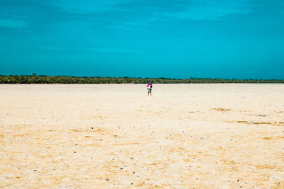 View of a tourist walking on the beach of mida creek in watamu during the low tide in malindi, kenya