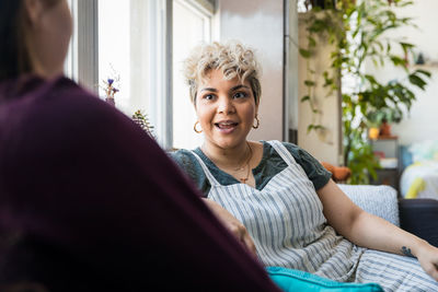 Portrait of smiling woman sitting at home