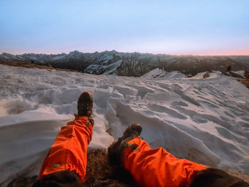 Rear view of people on mountain against sky during winter