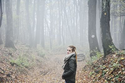 Side view of man standing in forest