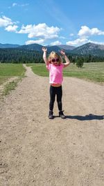 Full length of woman standing on land against sky