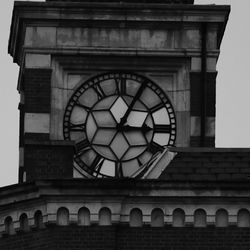 Low angle view of clock against sky