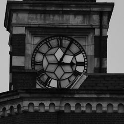 Low angle view of clock against sky