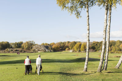 Rear view of senior women walking on golf course