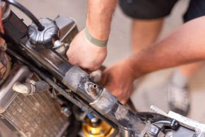 Cropped hands repairing motorcycle