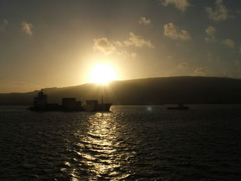 Boat sailing in sea at sunset