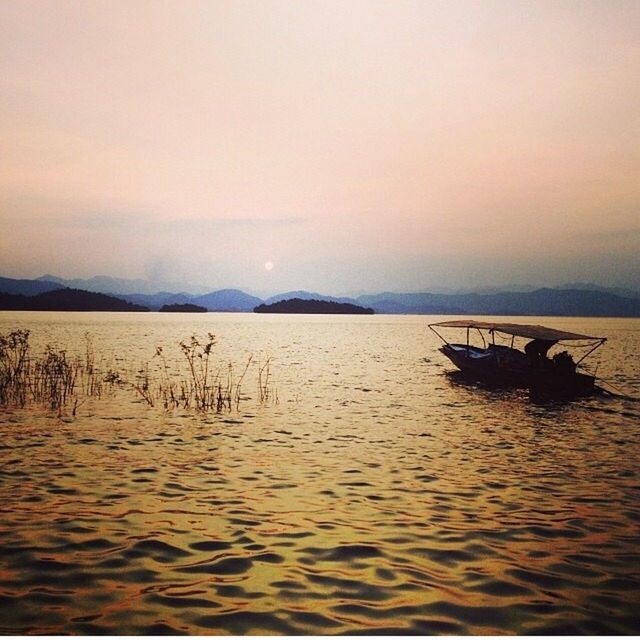 water, nautical vessel, transportation, tranquil scene, mode of transport, boat, scenics, tranquility, waterfront, sunset, beauty in nature, sky, nature, sea, mountain, idyllic, copy space, silhouette, lake, travel