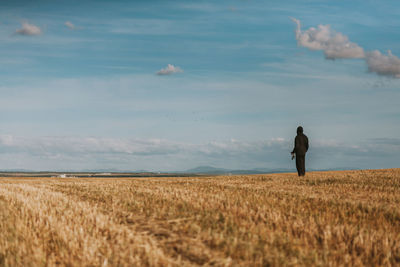 Full length of man standing on field against sky