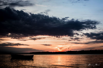 Scenic view of sea against dramatic sky during sunset