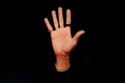 Cropped hand gesturing against black background