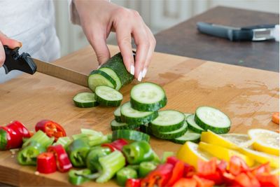 High angle view of man holding vegetables on table