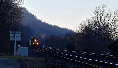 Train on railroad tracks against sky during winter