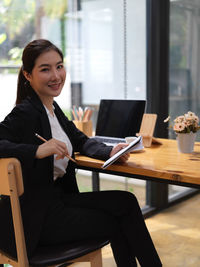 Portrait of smiling businesswoman sitting at restaurant