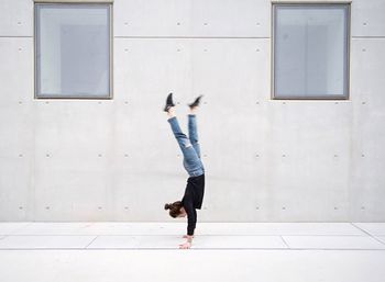 Woman doing handstand in city