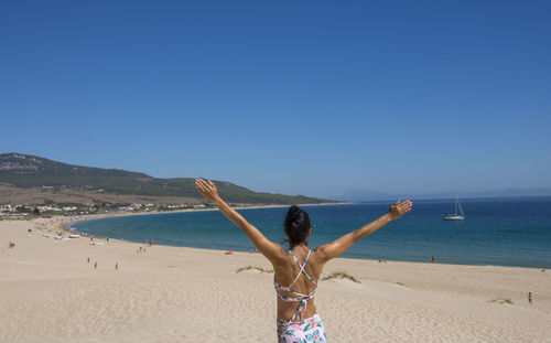Happy young woman in swimsuit at sand beach. relaxing, fun, and enjoy holiday at paradise
