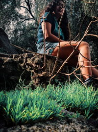 Woman sitting on grass in forest