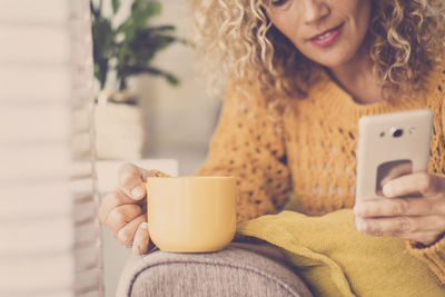 Midsection of woman holding coffee cup