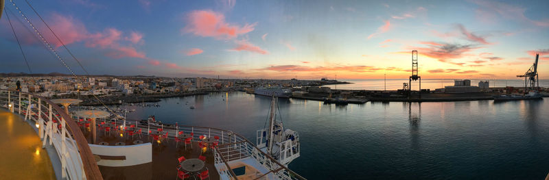 Panoramic view of harbor against sky during sunset