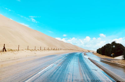 Panoramic view of desert road against sky