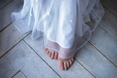 Low section of bride wearing wedding dress