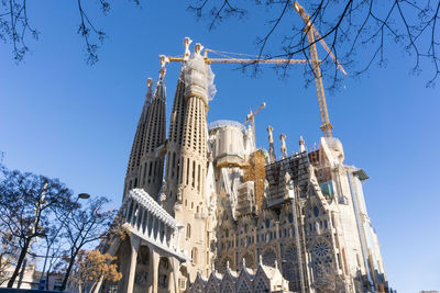 Low angle view of sagrada familia against clear blue sky