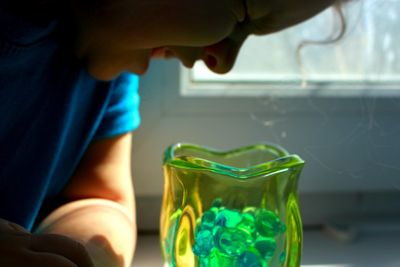 Close-up of girl looking in glass vase