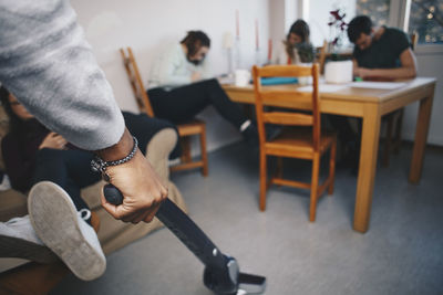 Cropped hand of man holding vacuum cleaner in dorm room