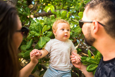 Parents looking at son on tree