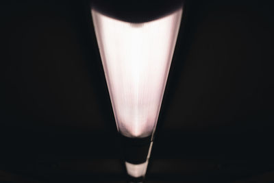 Close-up of illuminated light bulb in darkroom