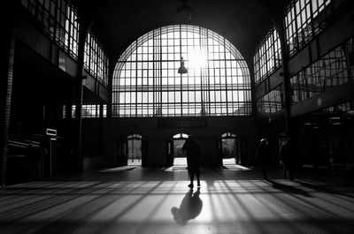 Rear view of silhouette woman walking in corridor of building