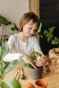 Young gardener. a cute little girl is planting or transplanting plants in a flower pot at home. 