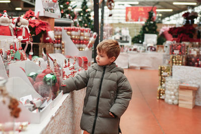 A boy choose the balls for the christmas tree