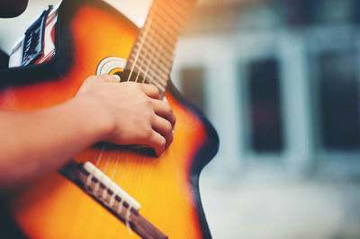 Close-up of person hand playing guitar