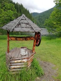 Old barn on field against trees