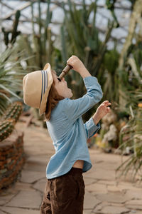 Preschooler boy inspecting desert cactus using magnifying glass. in the desert