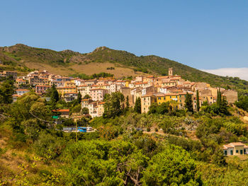 Townscape by buildings against clear sky