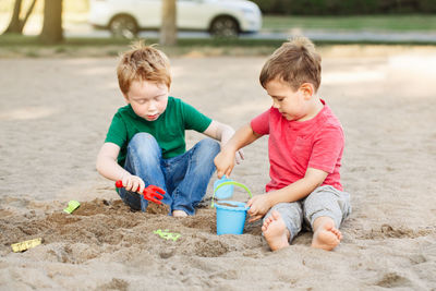 Boys playing with toy on sand at beach