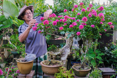 Woman standing by potted plants