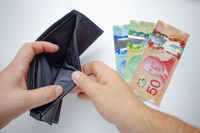 Close-up of hand holding paper over white background