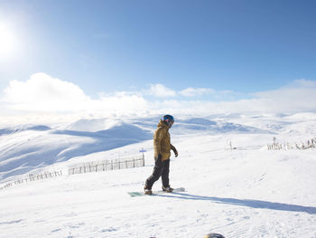 Full length of man skiing on snowcapped mountain against sky