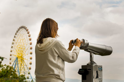 Low angle view of woman looking at camera against sky