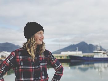 Young woman standing against dock