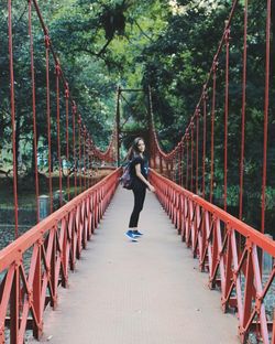 Rear view of woman standing on footbridge