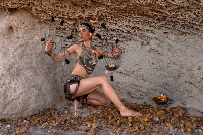 Young woman with umbrella on rock