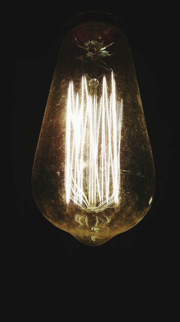 ILLUMINATED LIGHT BULB AGAINST BLACK BACKGROUND