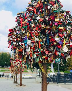 Close-up of multi colored decoration hanging in city against sky